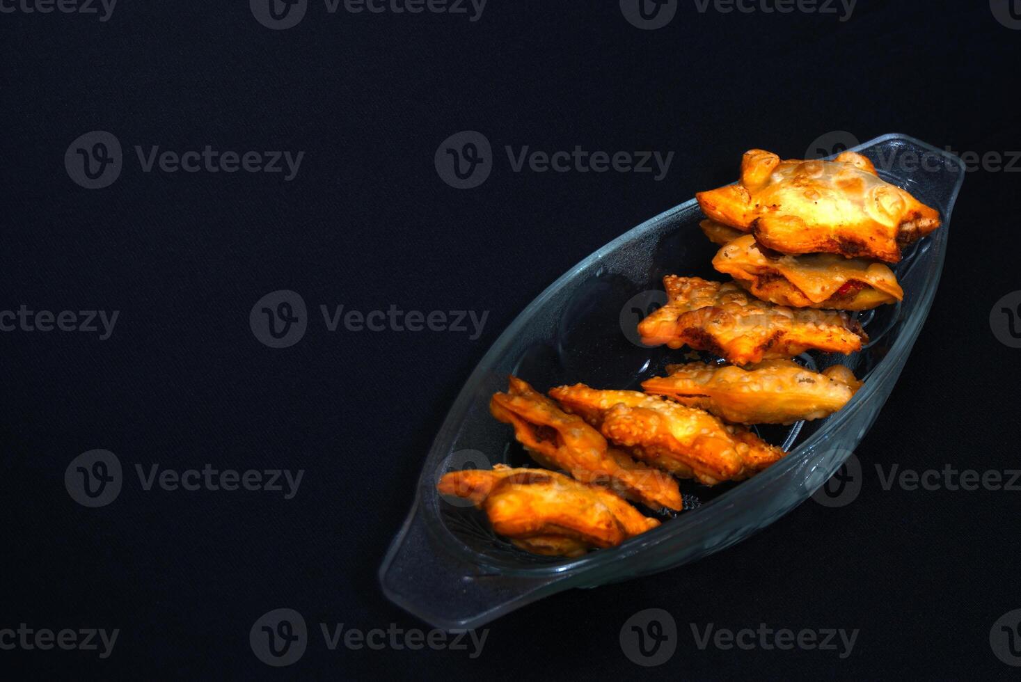 A glass bowl filled with succulent fried chicken wings, garnished and appetizing for a delightful meal. photo