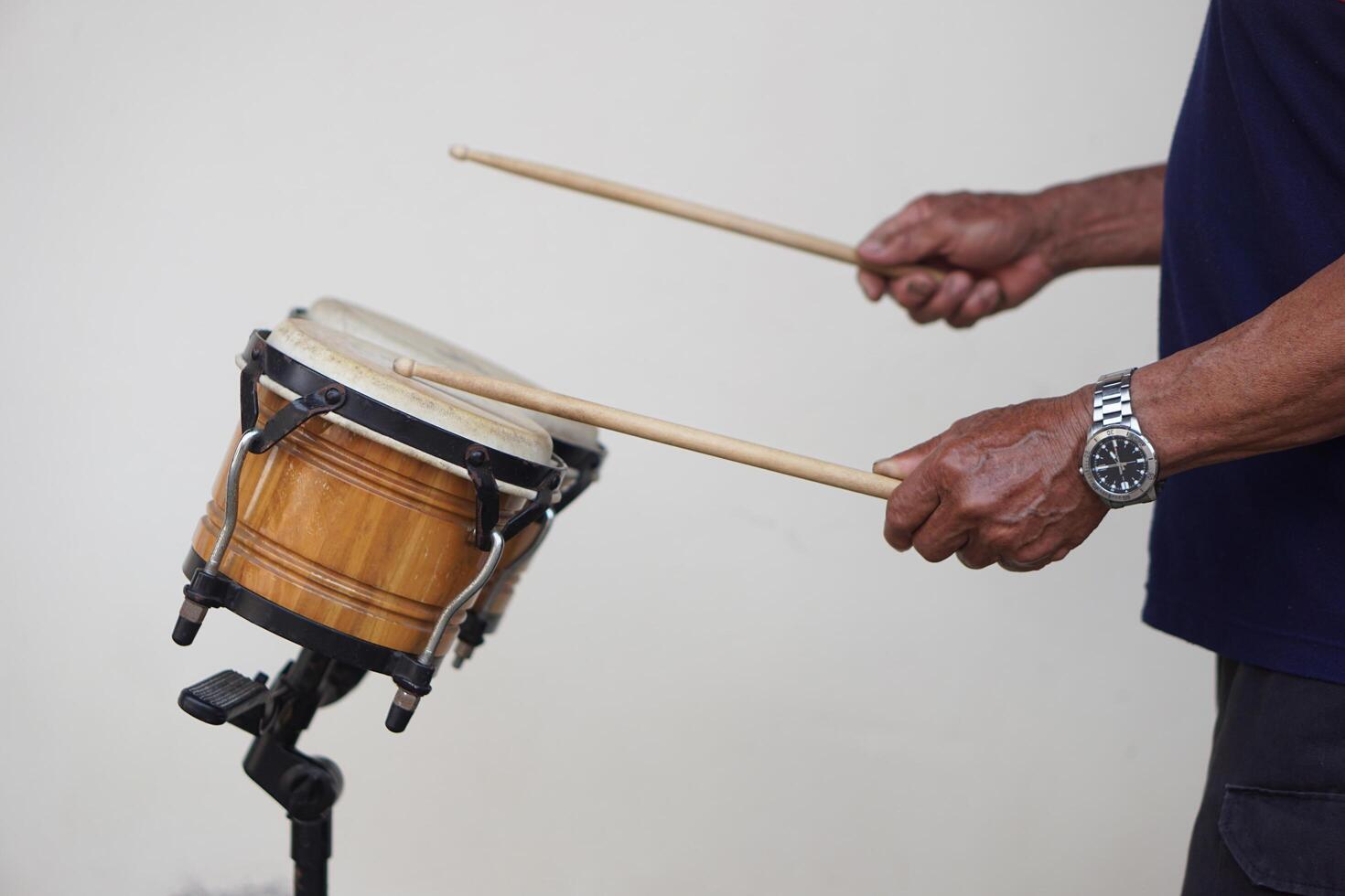 Man is beating bongo drums. Concept, musical percussion instrument for rhythm of music to make more fun for performing or dancing. Beat drum with rhythm along music and songs. photo