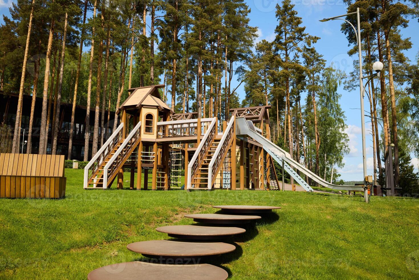 A Beautiful Wooden Playground Structure Nestled Amongst the Lush Trees in Natures Embrace photo