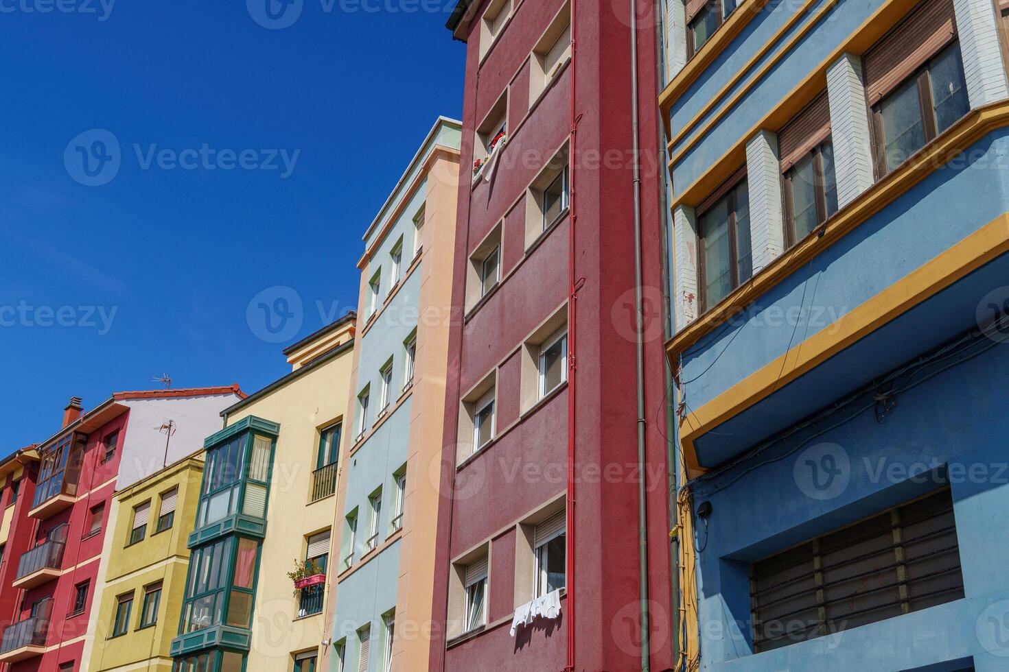 A blue sky with a few clouds and colourfull houses photo