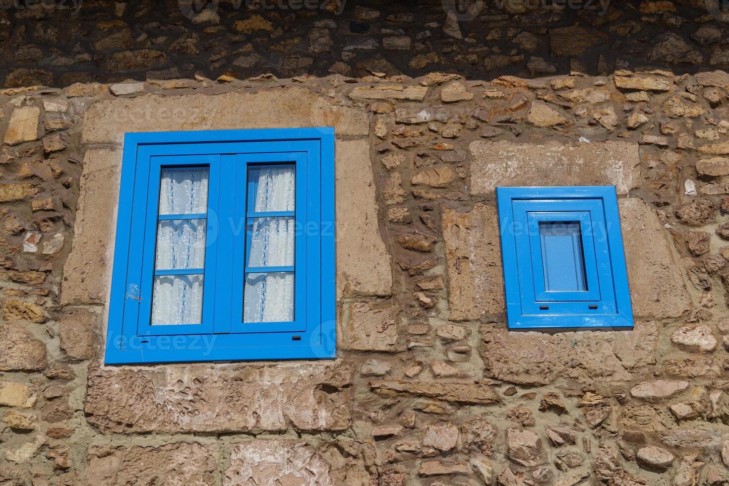 A stone wall with two blue windows photo