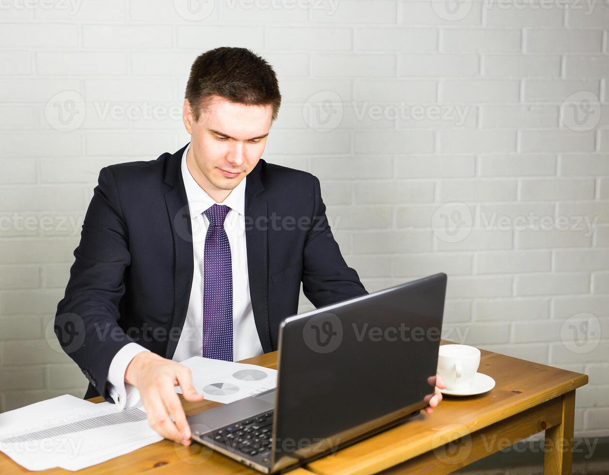 Handsome businessman working with laptop in office photo