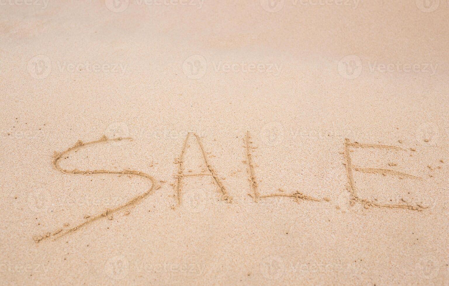 sale handwritten in sand on a beach photo