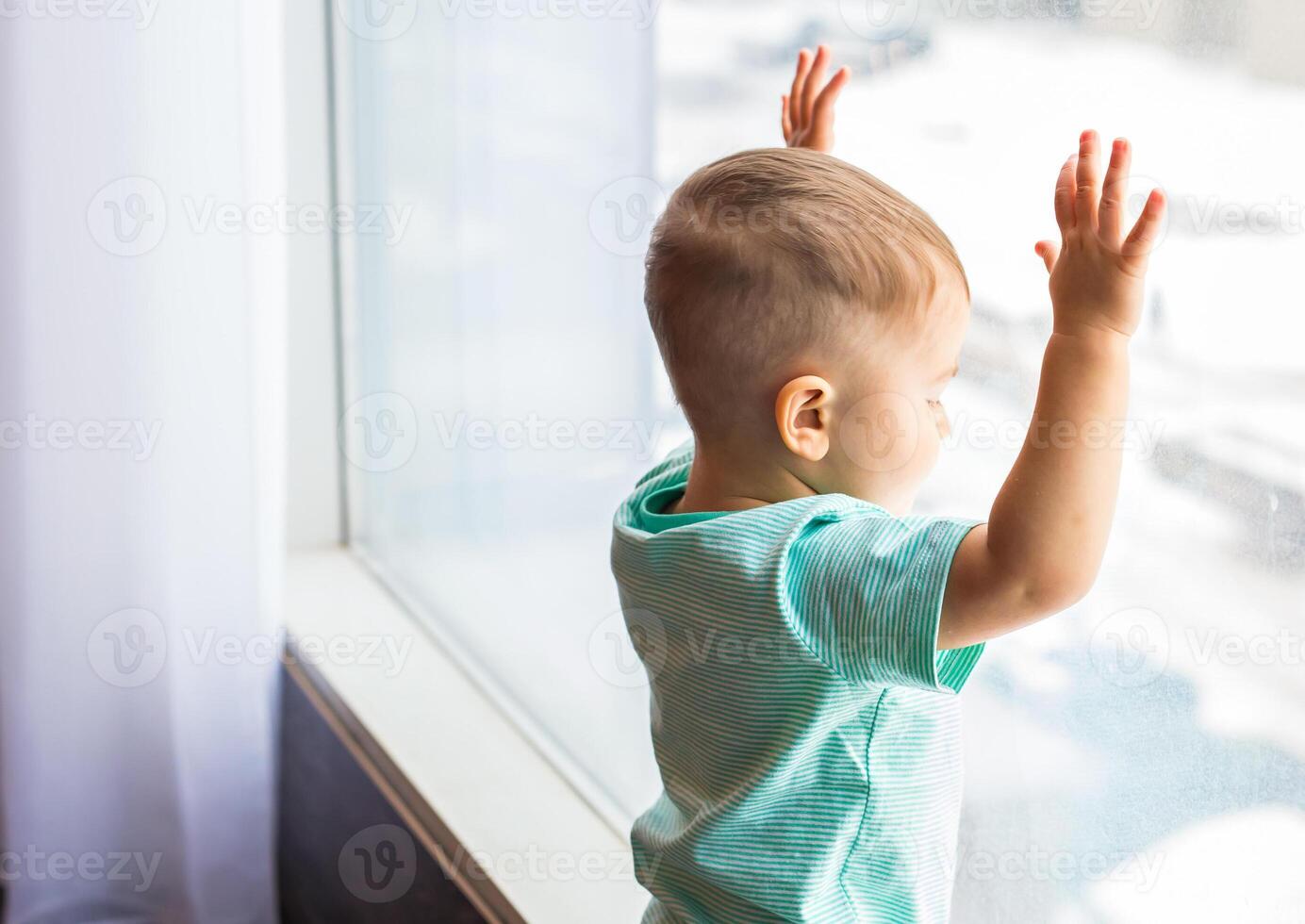 Smiling baby standing in room at home near window photo