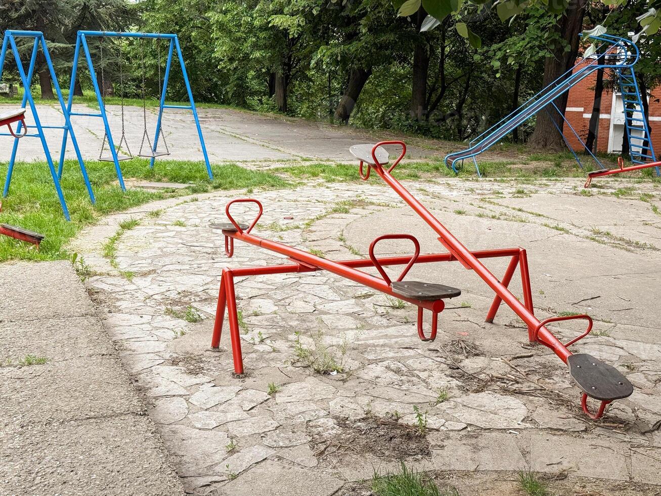 Colorful seesaws and swings in an empty outdoor playground. A quiet urban space for children's play and recreation. photo