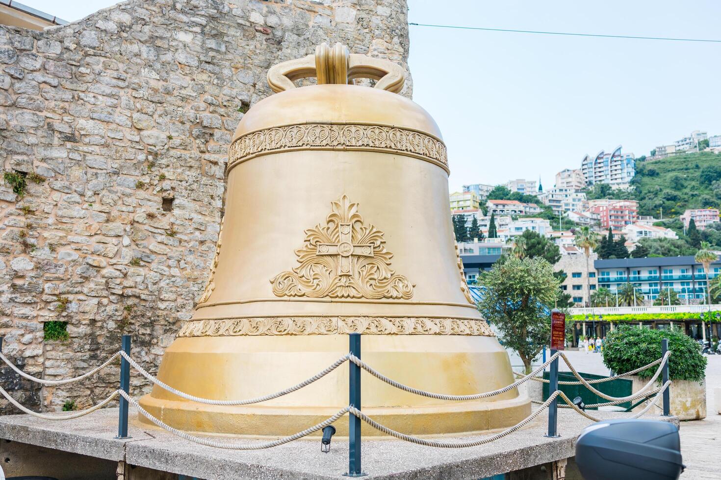 Budva, Montenegro - May 10, 2025 . Large cracked bell displayed outside the walls of Budva Old Town in Montenegro photo