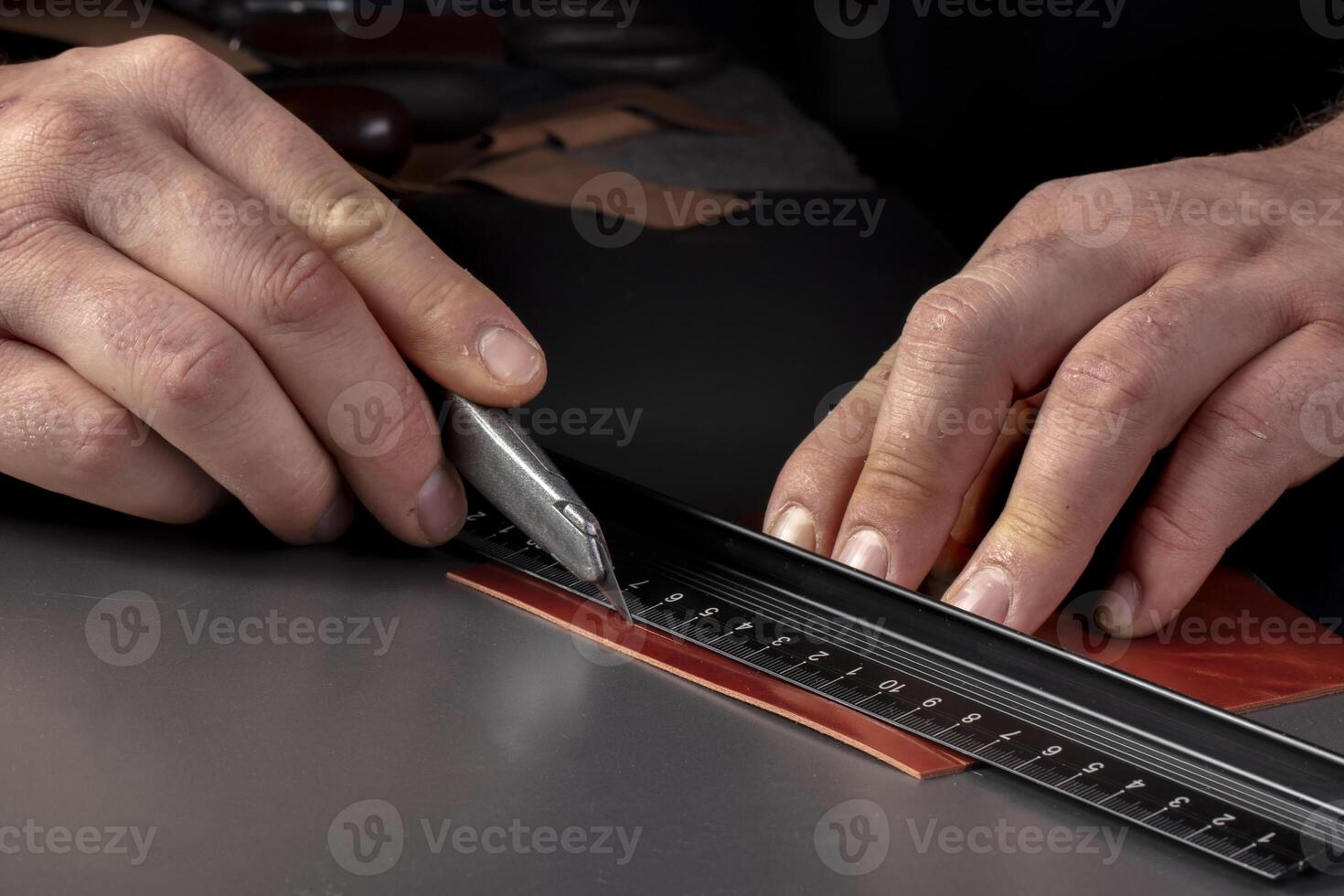The process of making leather goods The hands of the master work with a leather product. photo