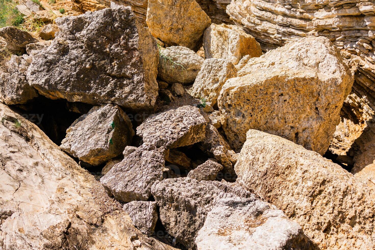 Broken limestone blocks scattered across a rocky slope. Natural erosion, geology, and raw mineral texture in an outdoor setting. photo