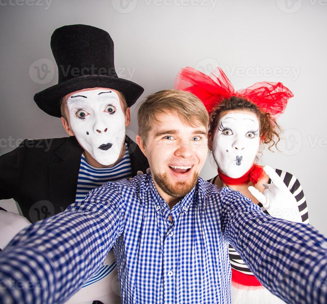 A young man and Funny couple of mimes taking a selfie photo
