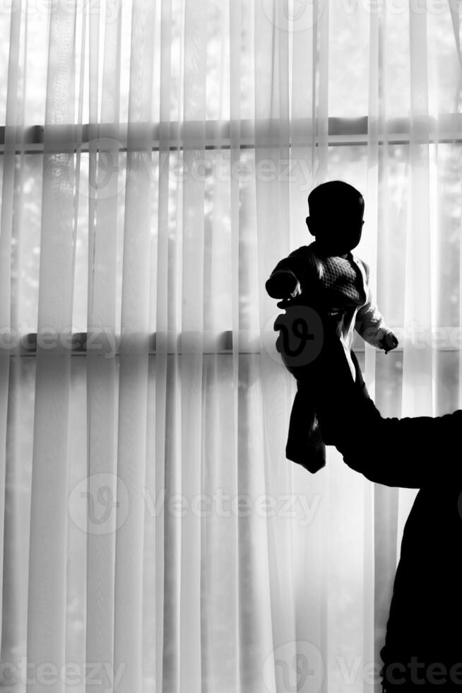 silhouettes of father and little baby playing photo