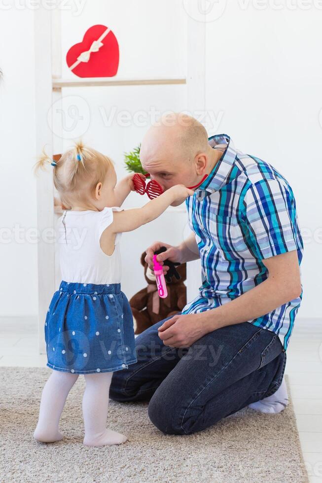 Father plays with his cheerful baby girl daughter. Single parent. Fatherhood, father's day and family photo