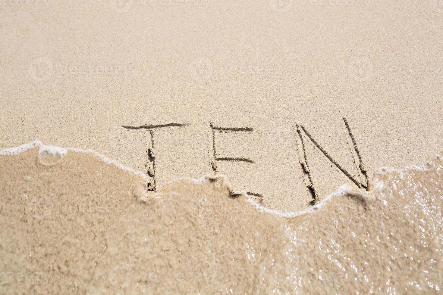 Ten number written on sand. Summer beach background photo