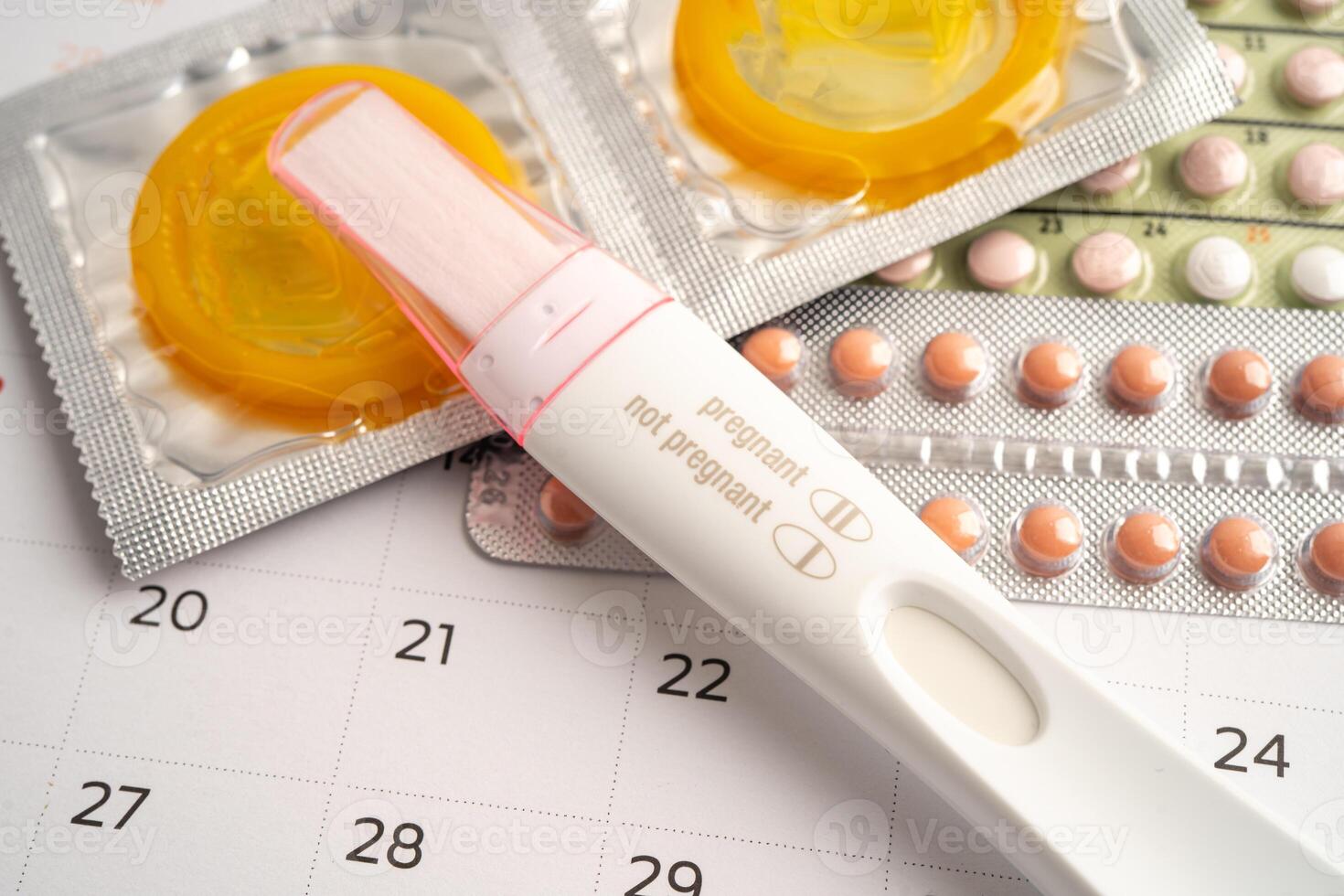 Pregnancy test birth control pills on calendar, contraception photo