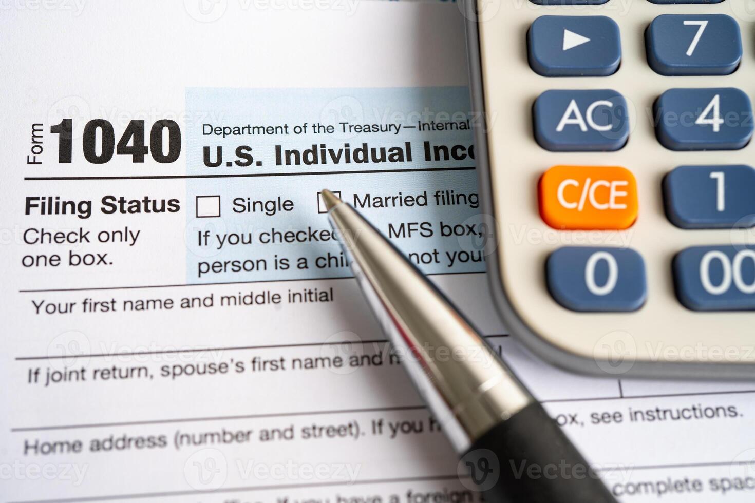 Tax Return form 1040 with pen and calculator, U.S. Individual Income. photo