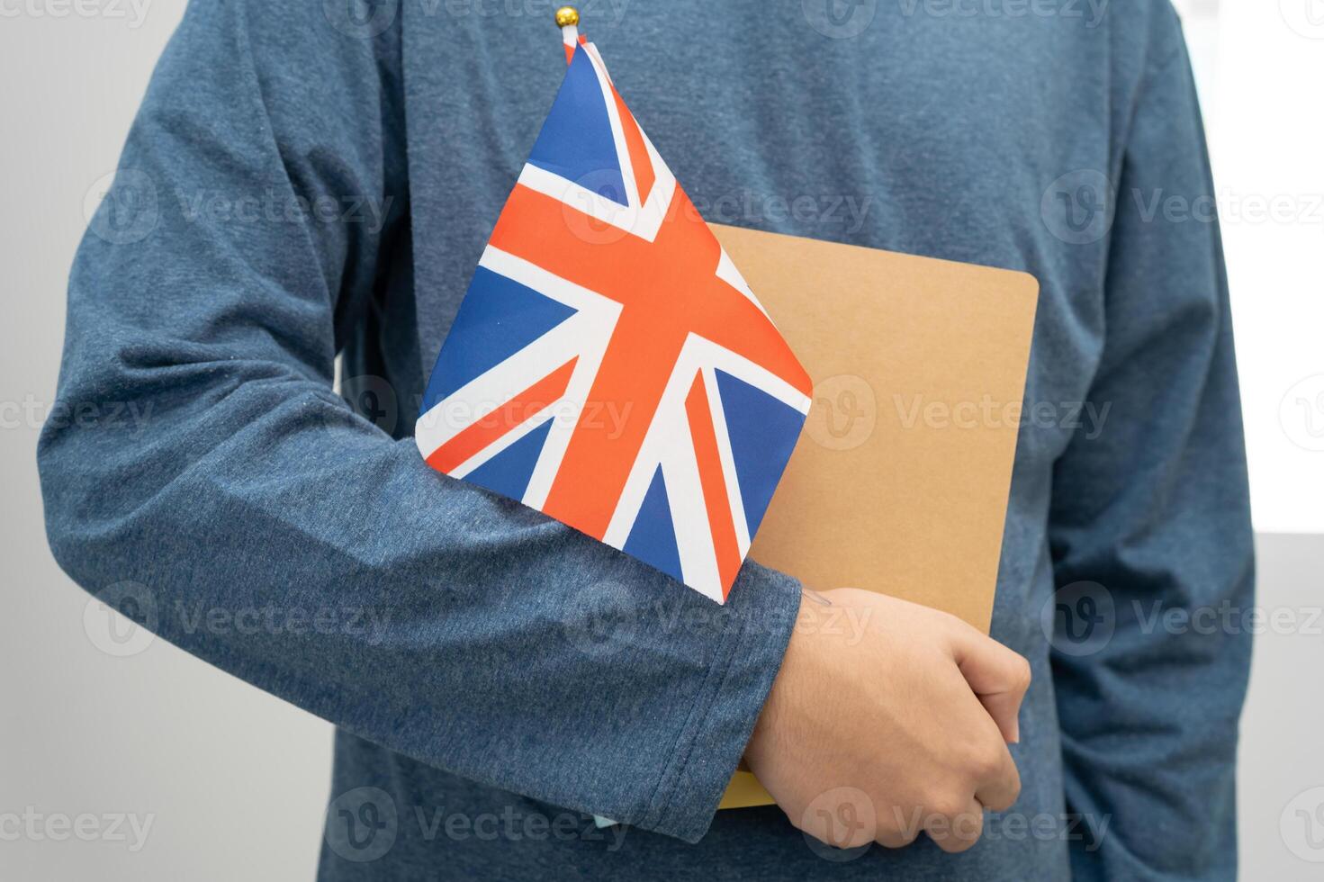 Learn English language Asian teenage student hold book with flag in course at school. photo