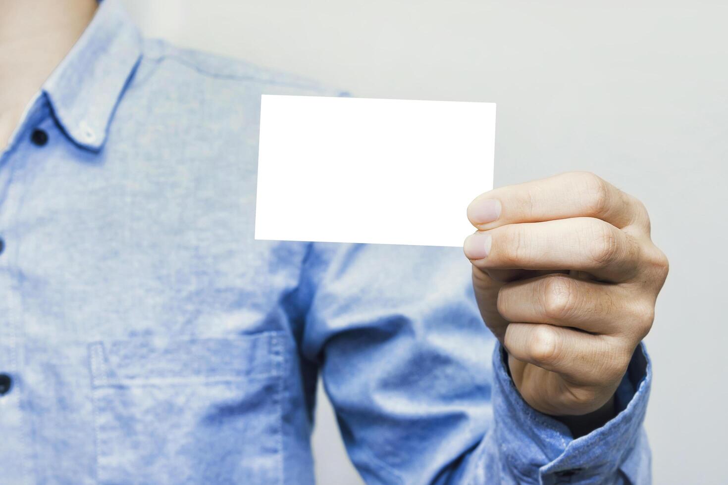 Simple white business card mockup shown in hand. Ideal for corporate identity, partnership presentations, advertising, communication to promote success and professional connection. photo