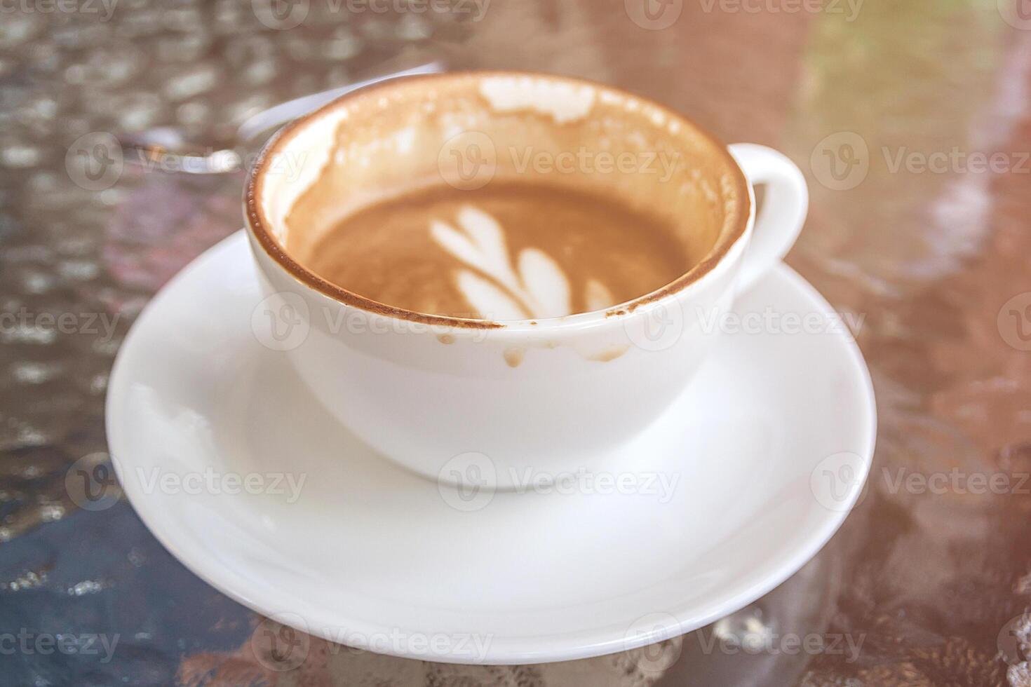 white cup of coffee latte, half drank in the cup already been enjoyed photo