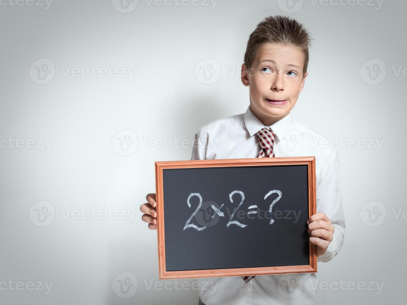 Funny schoolboy has thought of the task decision photo
