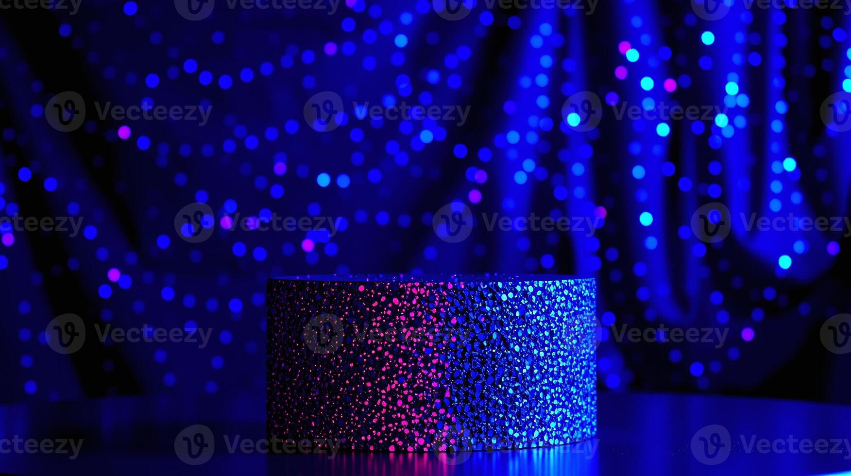 A cylinder with a glittering texture stands against a backdrop of blue and pink bokeh lights. photo