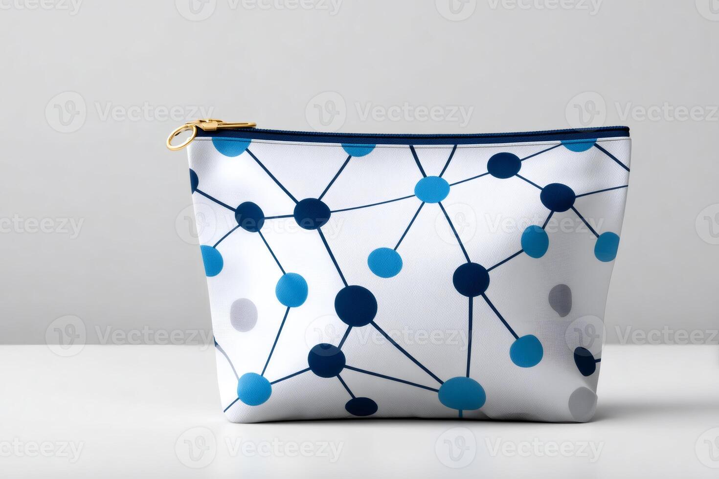 White cosmetic bag with blue molecule pattern resting on white surface photo