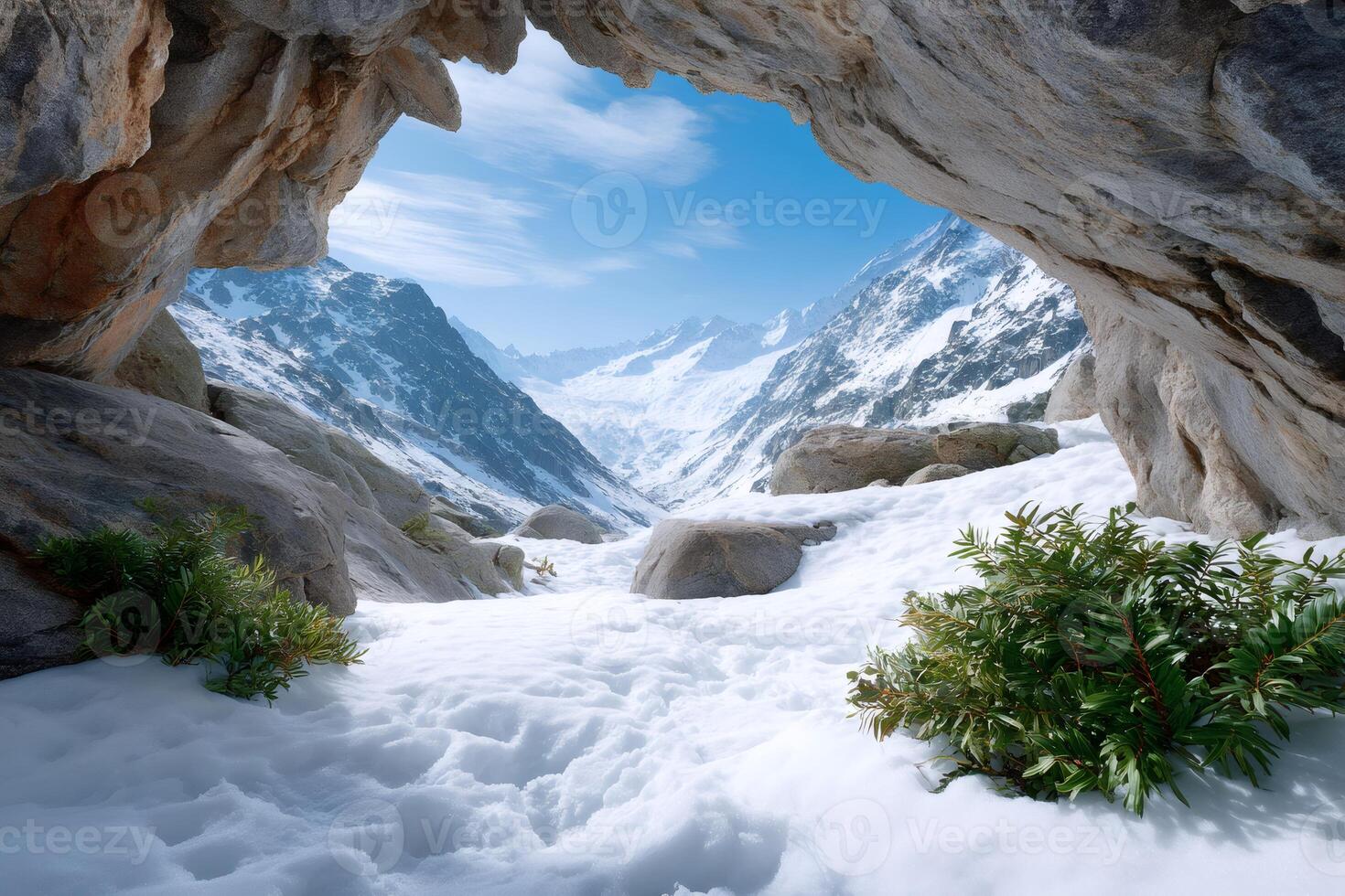 Discovering breathtaking snowy mountain landscape from inside a cave photo