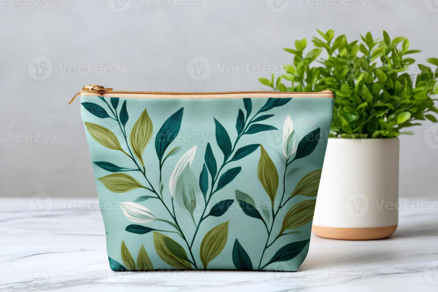 Stylish makeup bag with botanical print showing green and white leaves on turquoise background photo