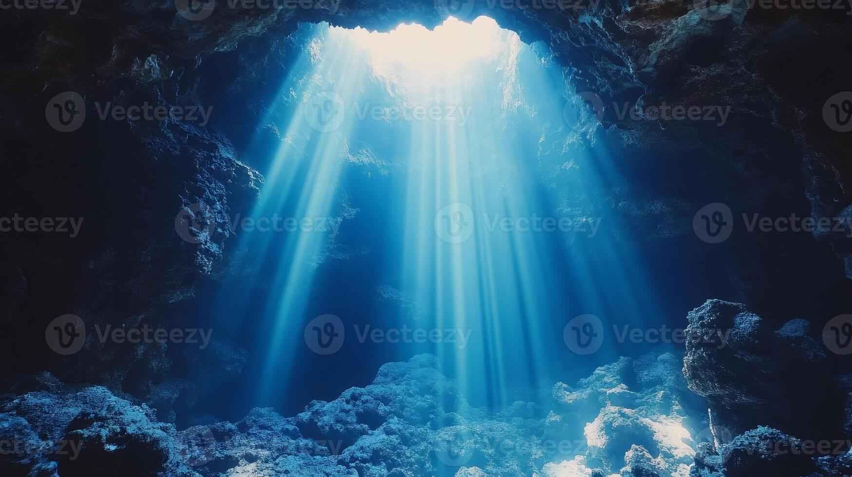 Underwater cave with sunbeams shining through opening photo