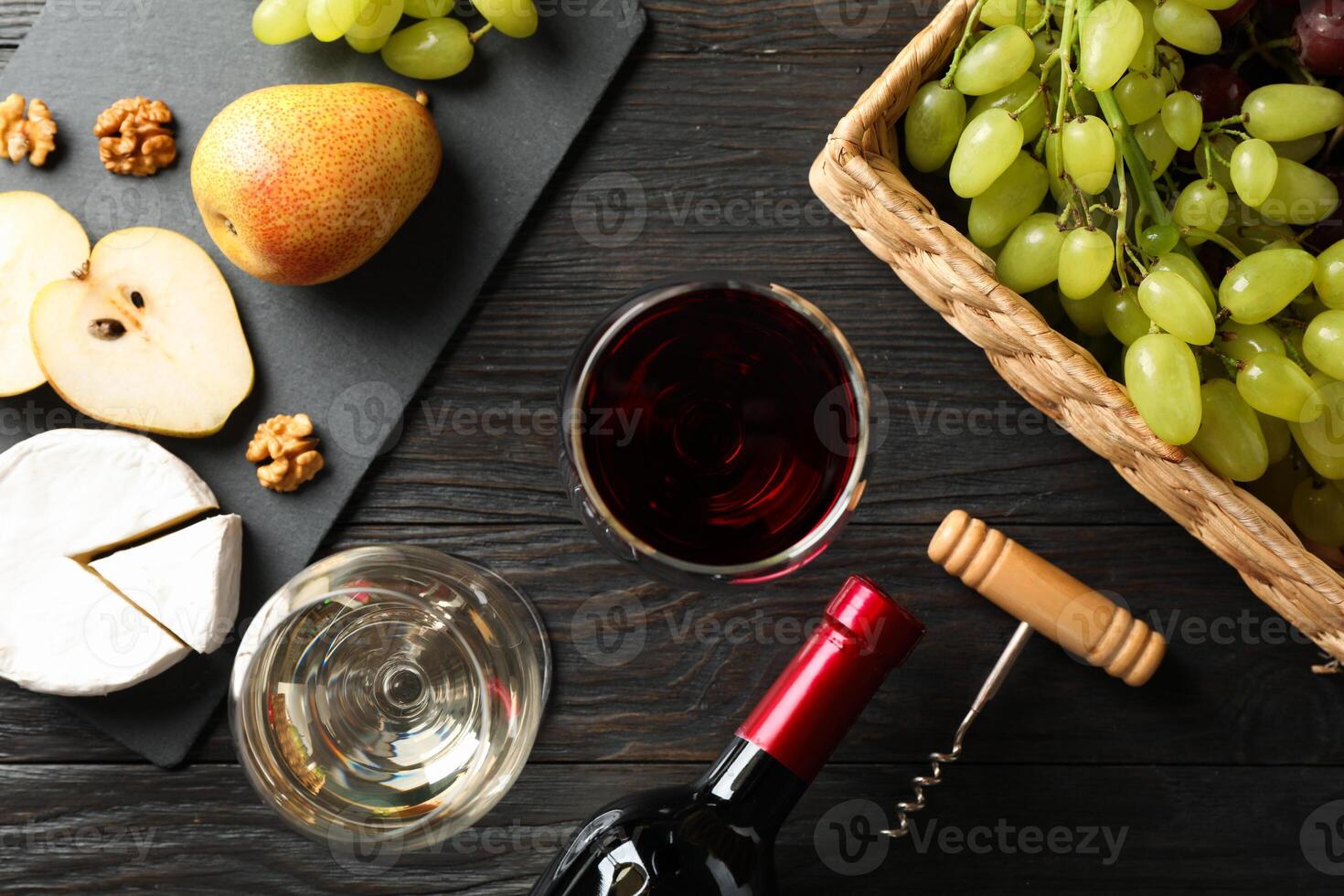 Grape, cheese, walnut, glasses with wine, on wooden background, top view photo