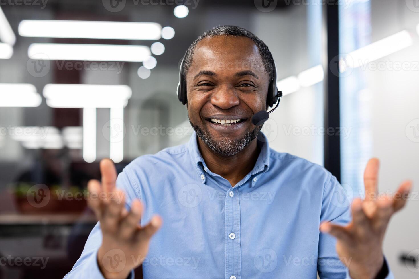 Cheerful African American businessman with headset in office setting displays confident communication and positive energy. Ideal for business, communication, and technology concepts. photo