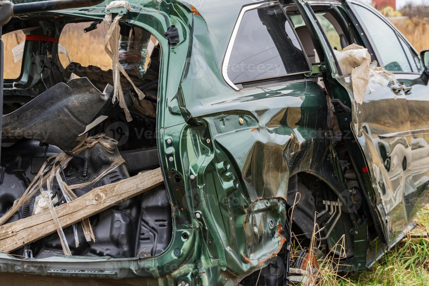 Significant damage is evident on the green vehicle from a recent accident, highlighting the dangers of unsafe driving in rural settings photo