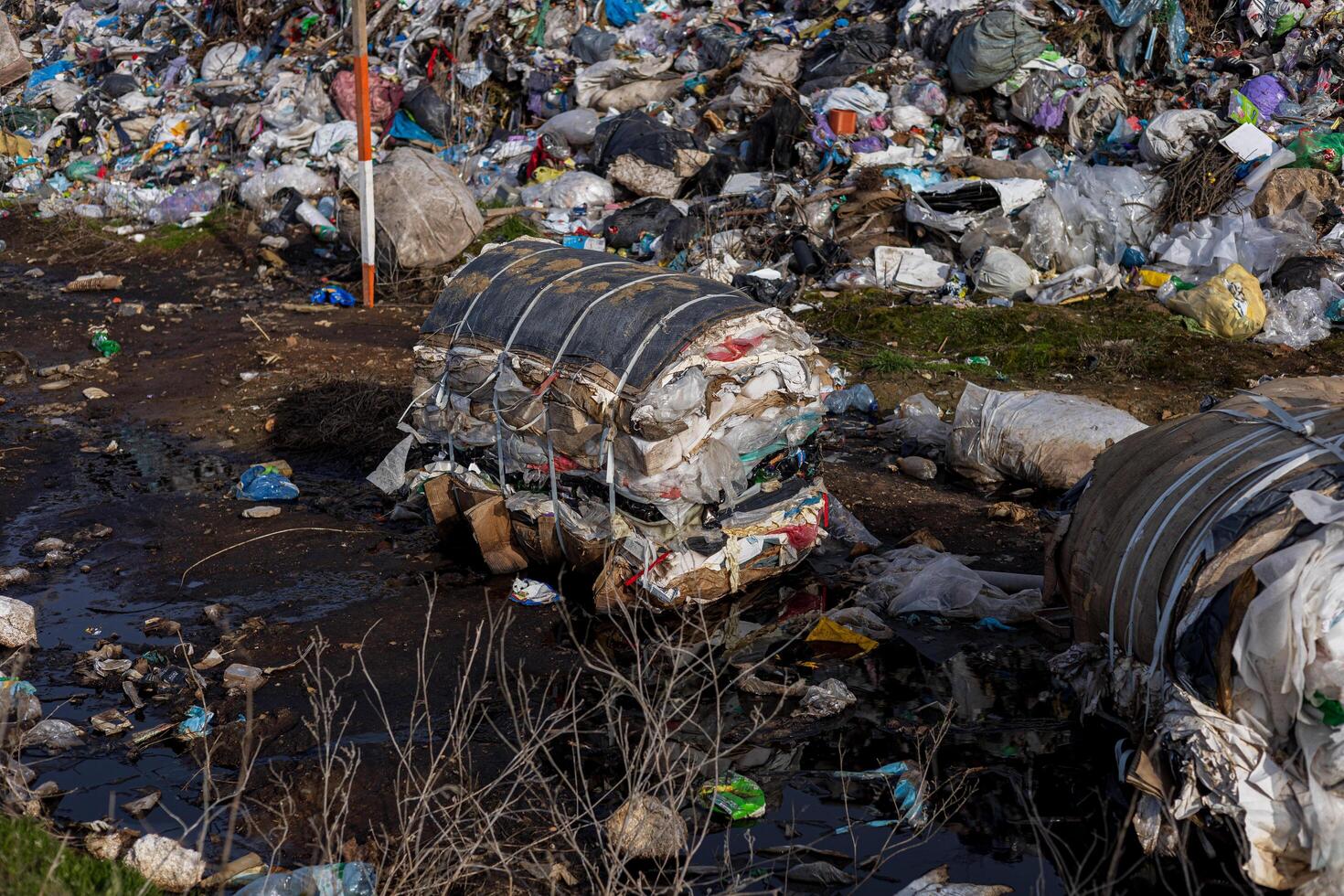 Plastic waste and other debris accumulate at a landfill site, posing significant challenges to environmental management and recycling efforts photo