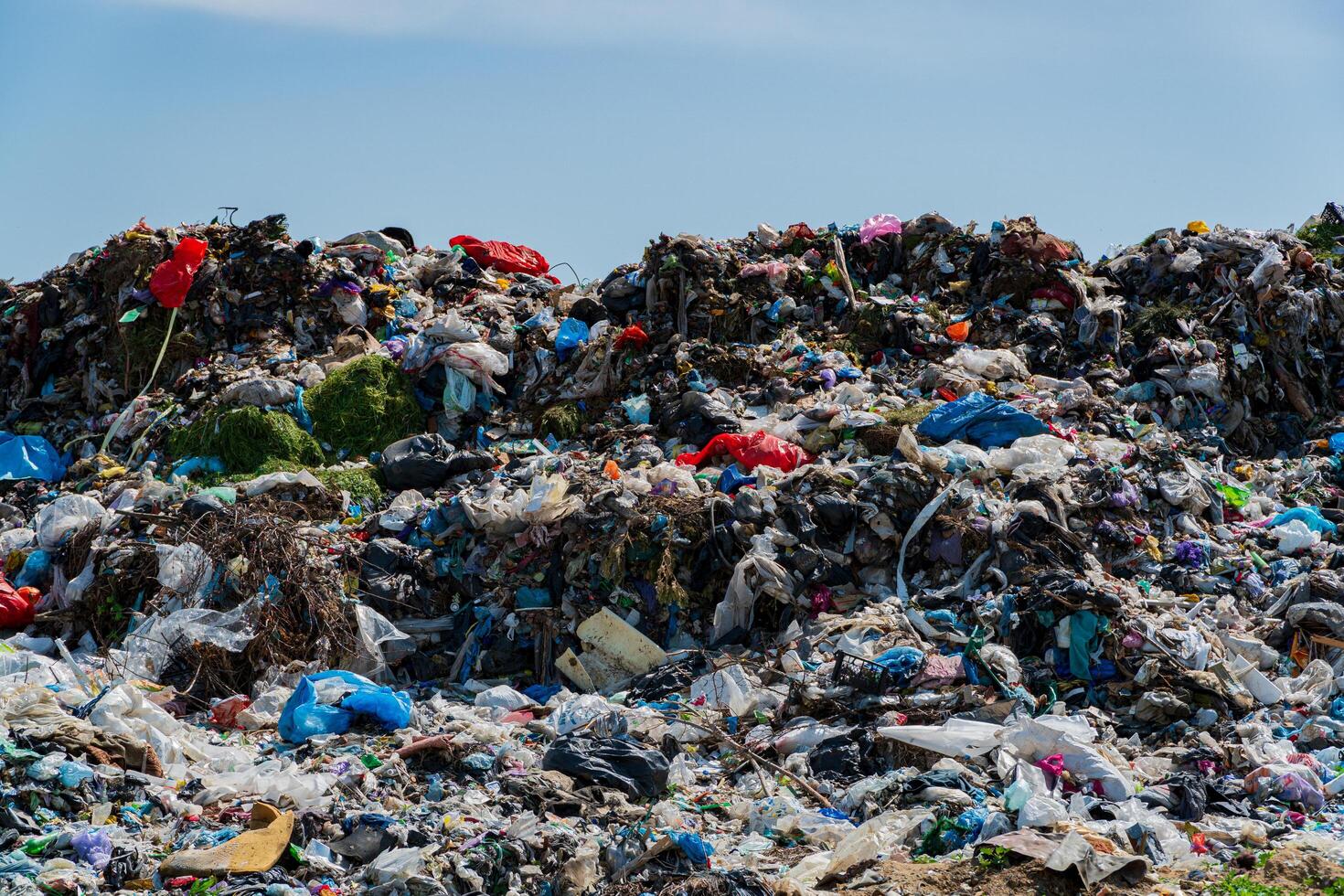 Landfill filled with heaps of garbage, plastic waste, and debris severely impacting the surrounding environment and ecological balance photo