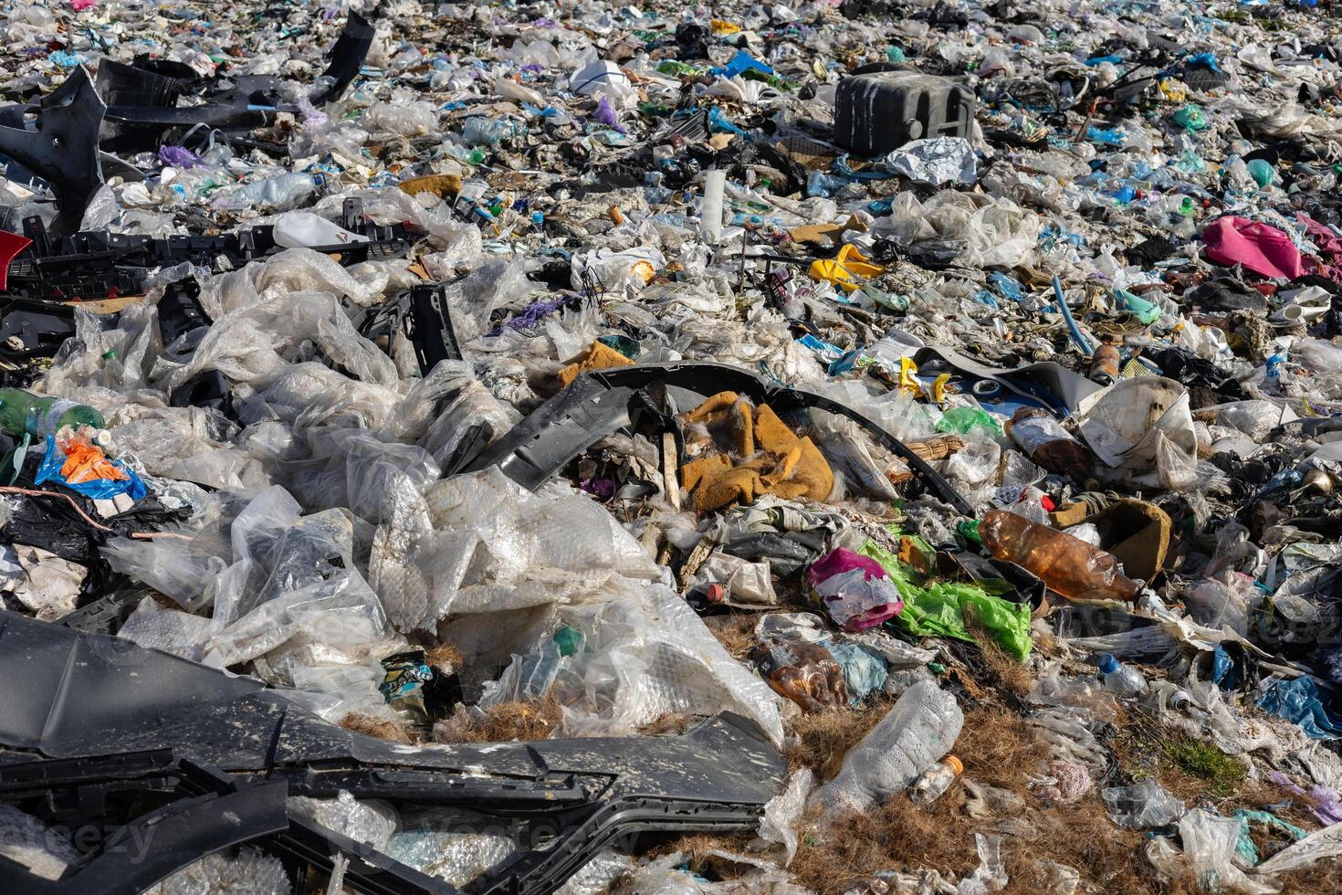 A vast landfill filled with layers of plastic waste and garbage, illustrating the serious issue of pollution and the need for recycling solutions photo