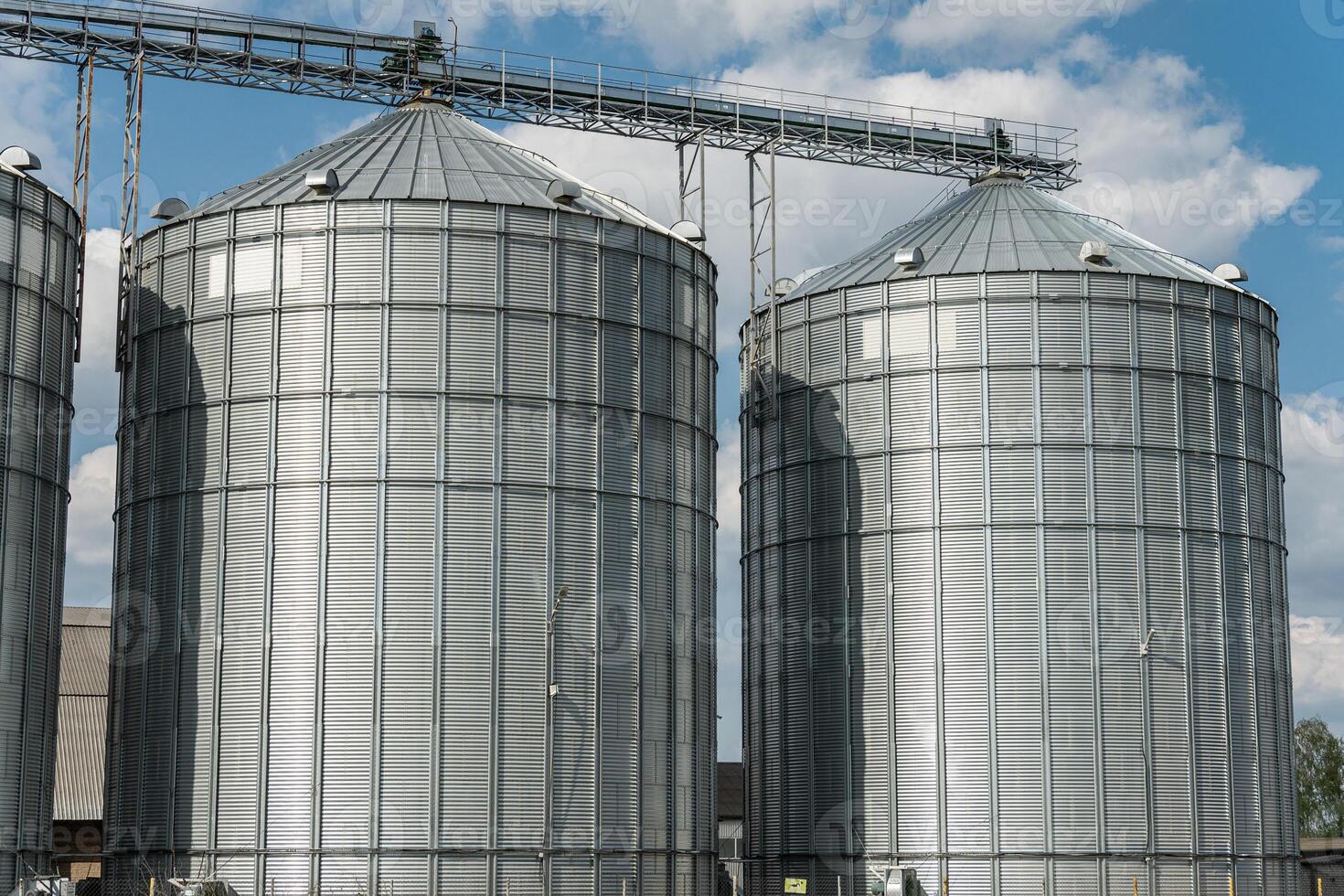 Multiple grain silos are prominently featured at a storage facility, showcasing their role in agriculture and harvest management photo