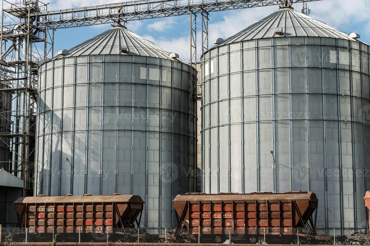 Two metallic silos stand tall at a grain storage facility, capturing the essence of agricultural harvest and efficient grain handling photo