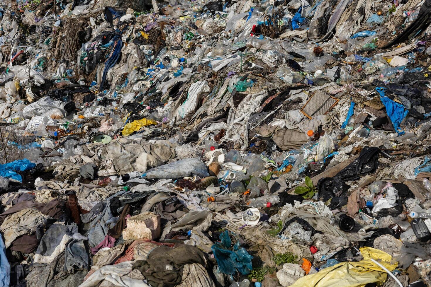 A vast expanse of mixed trash and debris covers a landfill, highlighting environmental challenges and the impact of waste accumulation photo