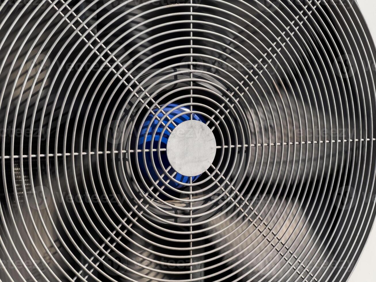 A detailed view of a large industrial fan showcasing metallic lines and a vibrant blue center, typical in modern ventilation systems photo
