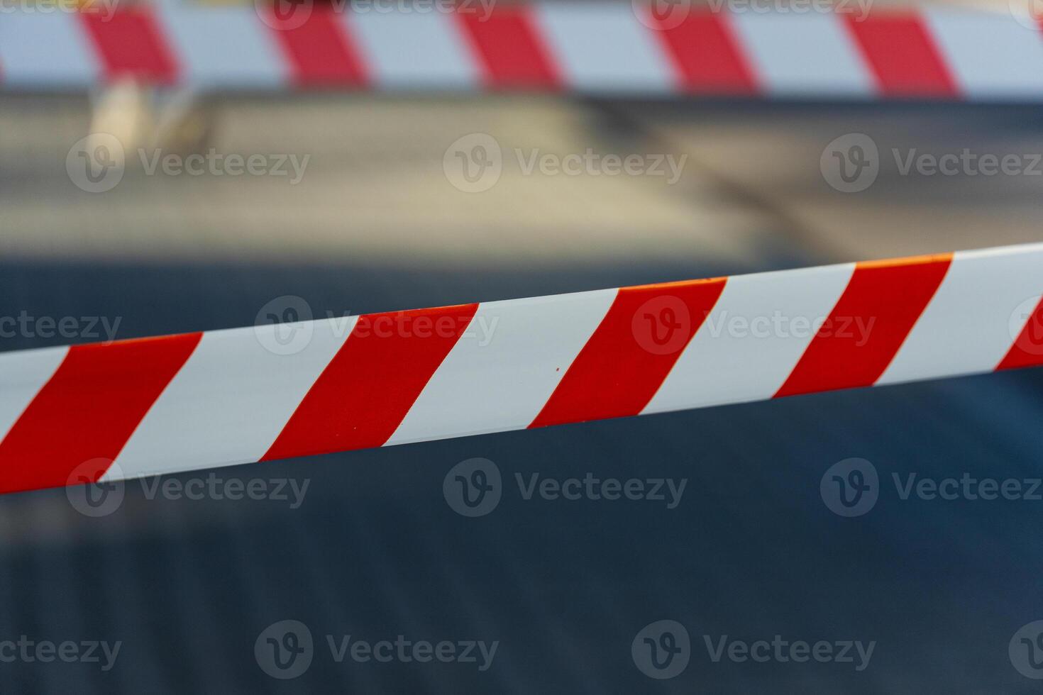 Brightly colored barricade tape indicates a restricted area at a construction site in an urban environment under clear sky photo