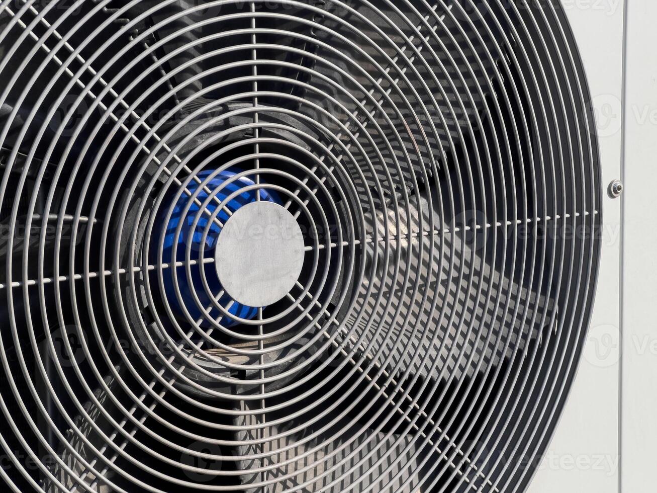 An industrial fan is set up outdoors, efficiently circulating air in a warm environment, ensuring comfort and cooling photo