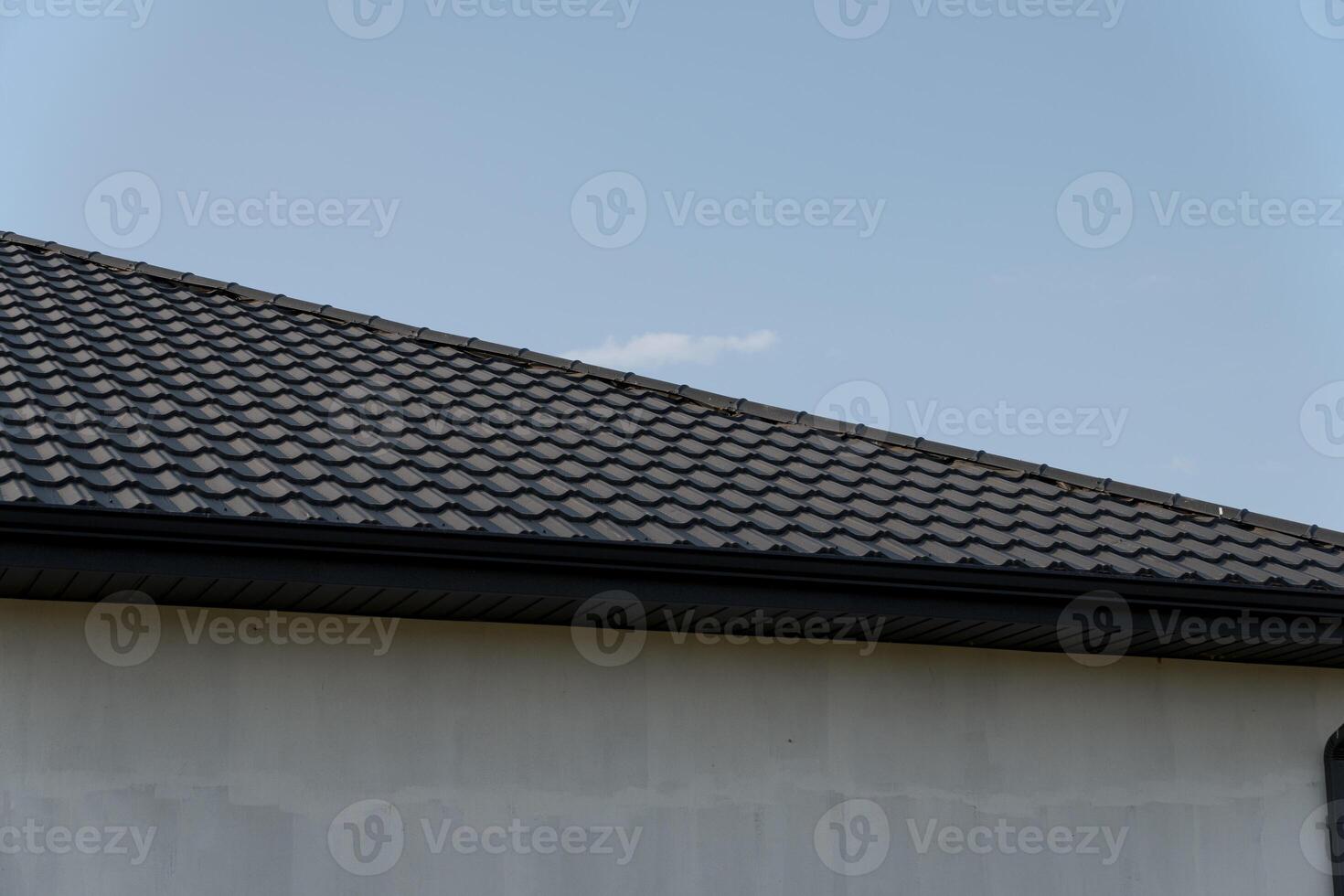 New roof installation features modern tiles on a residential home with a cloudy sky in the background, highlighting the construction work photo