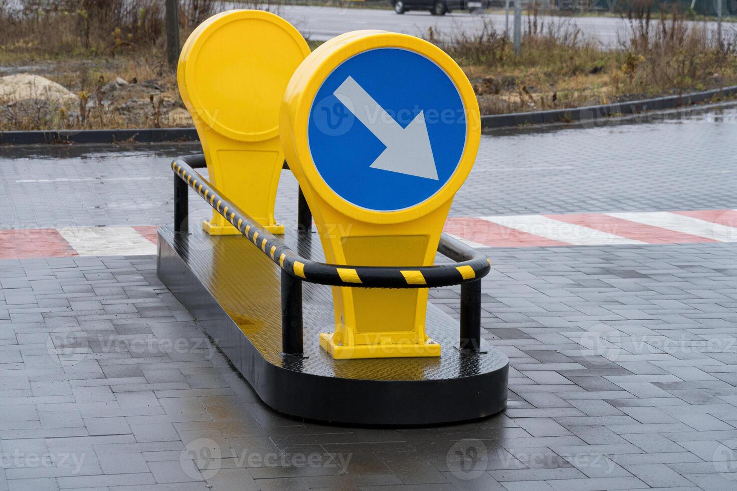 The bright yellow directional signs point the way amid a modern cityscape, showcasing safety features in a cloudy urban environment photo