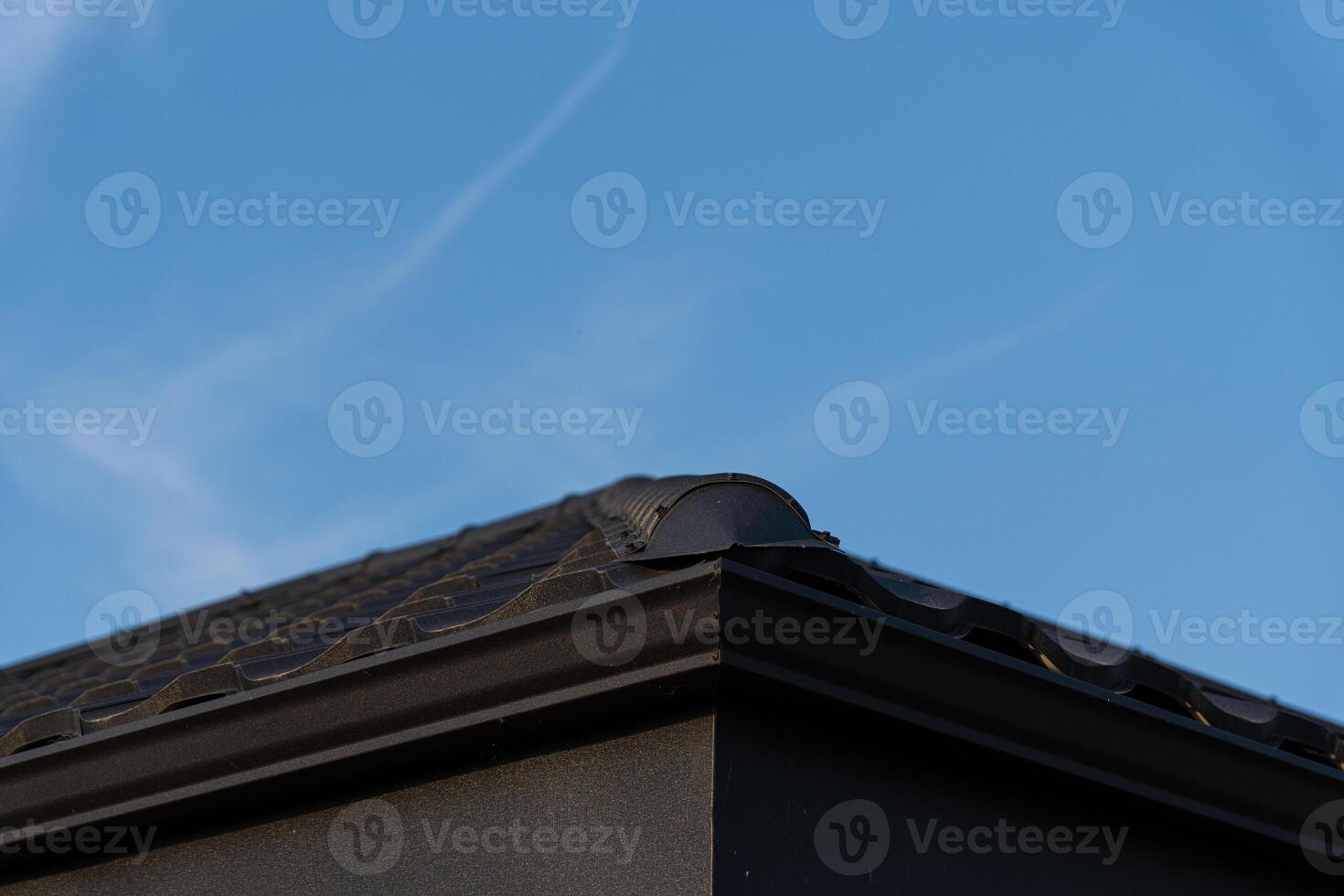 A black roof structure is visible against a clear blue sky, showcasing its sleek design during the day with no obstructions photo
