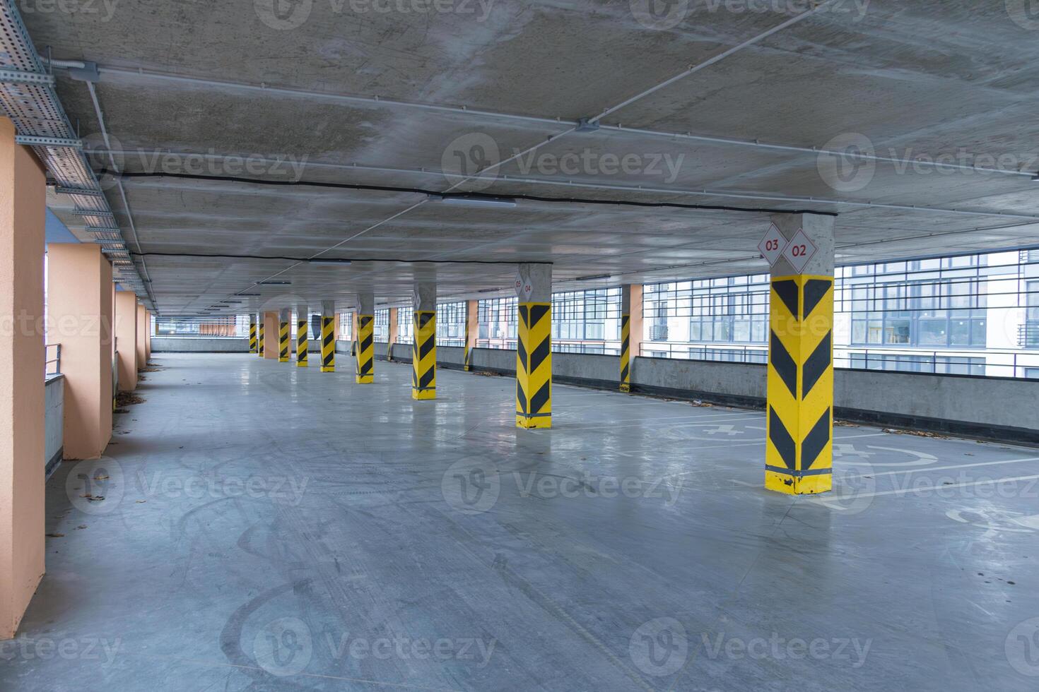 Spacious parking structure features minimal vehicles and marked columns, showcasing clean lines and industrial architecture photo