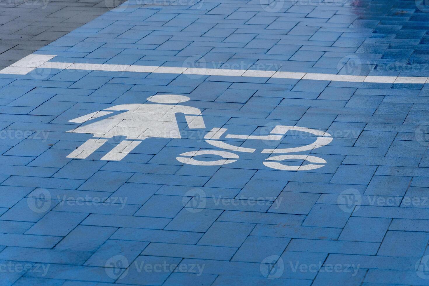 A blue parking area clearly marked for parents with strollers, showcasing a symbol of a woman with a stroller under bright lighting photo