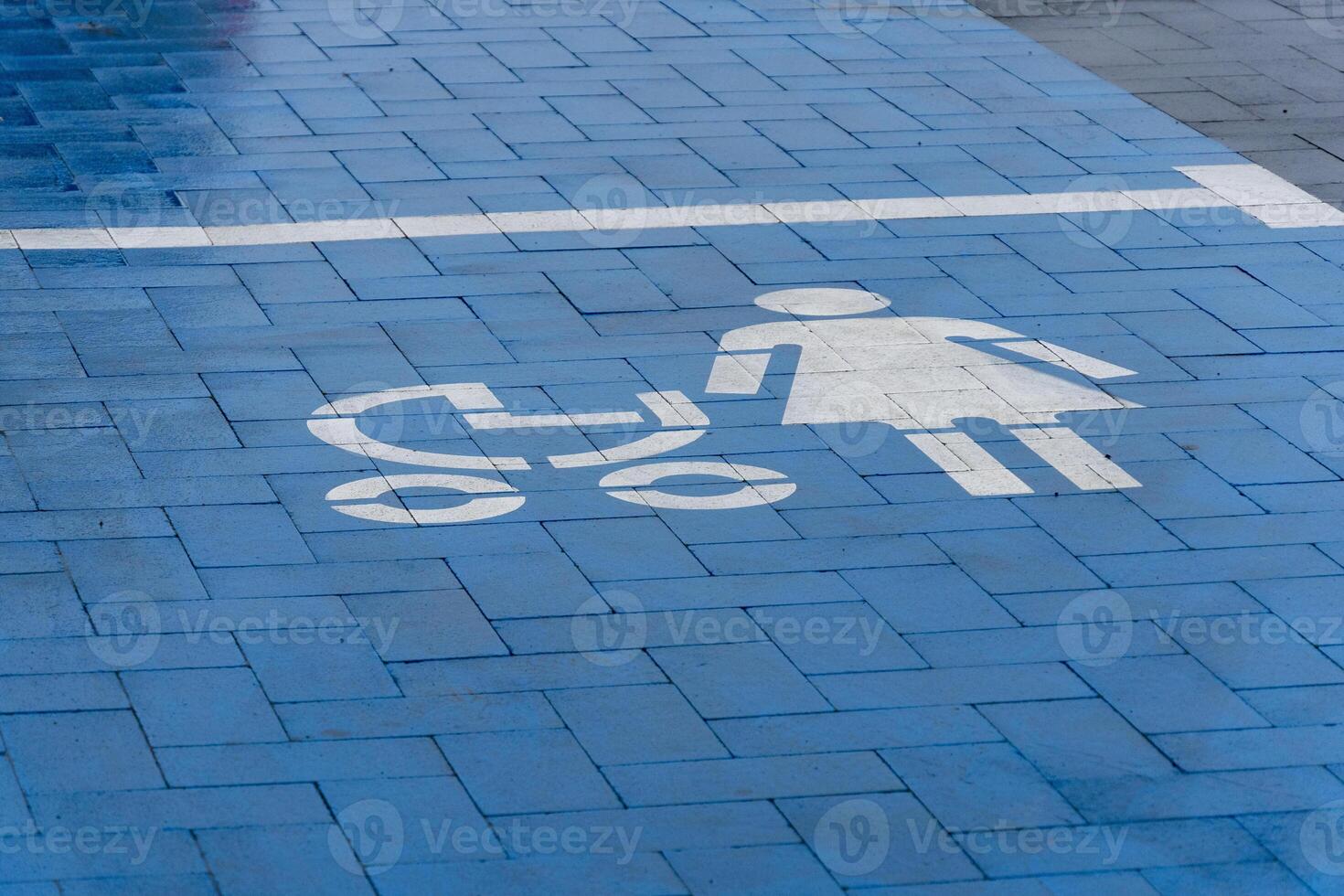 A blue marked parking space for mothers with strollers is visible, promoting accessibility for families in a busy location photo