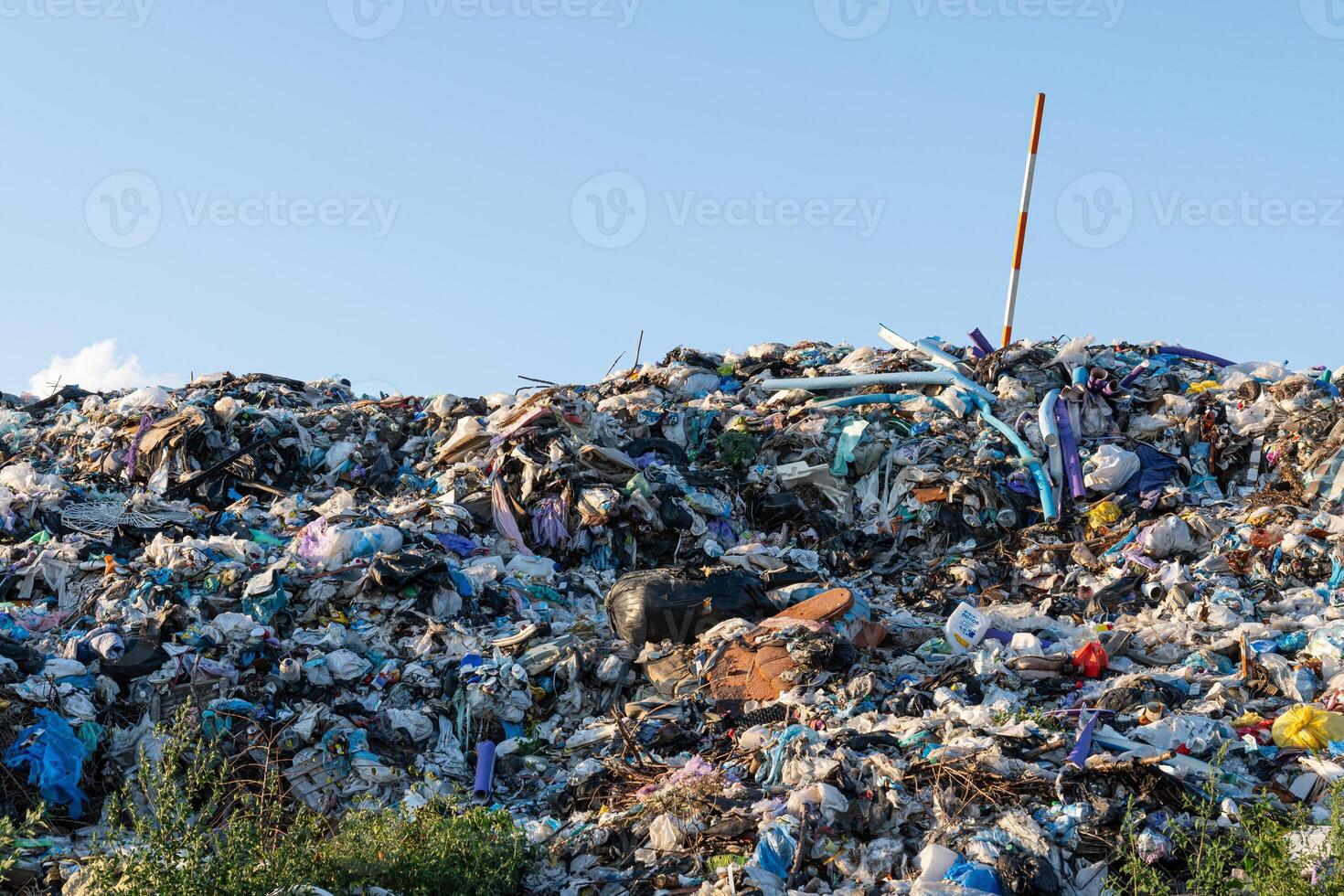 A massive heap of trash cluttered with plastic stands out under the blue sky, highlighting major waste management problems photo