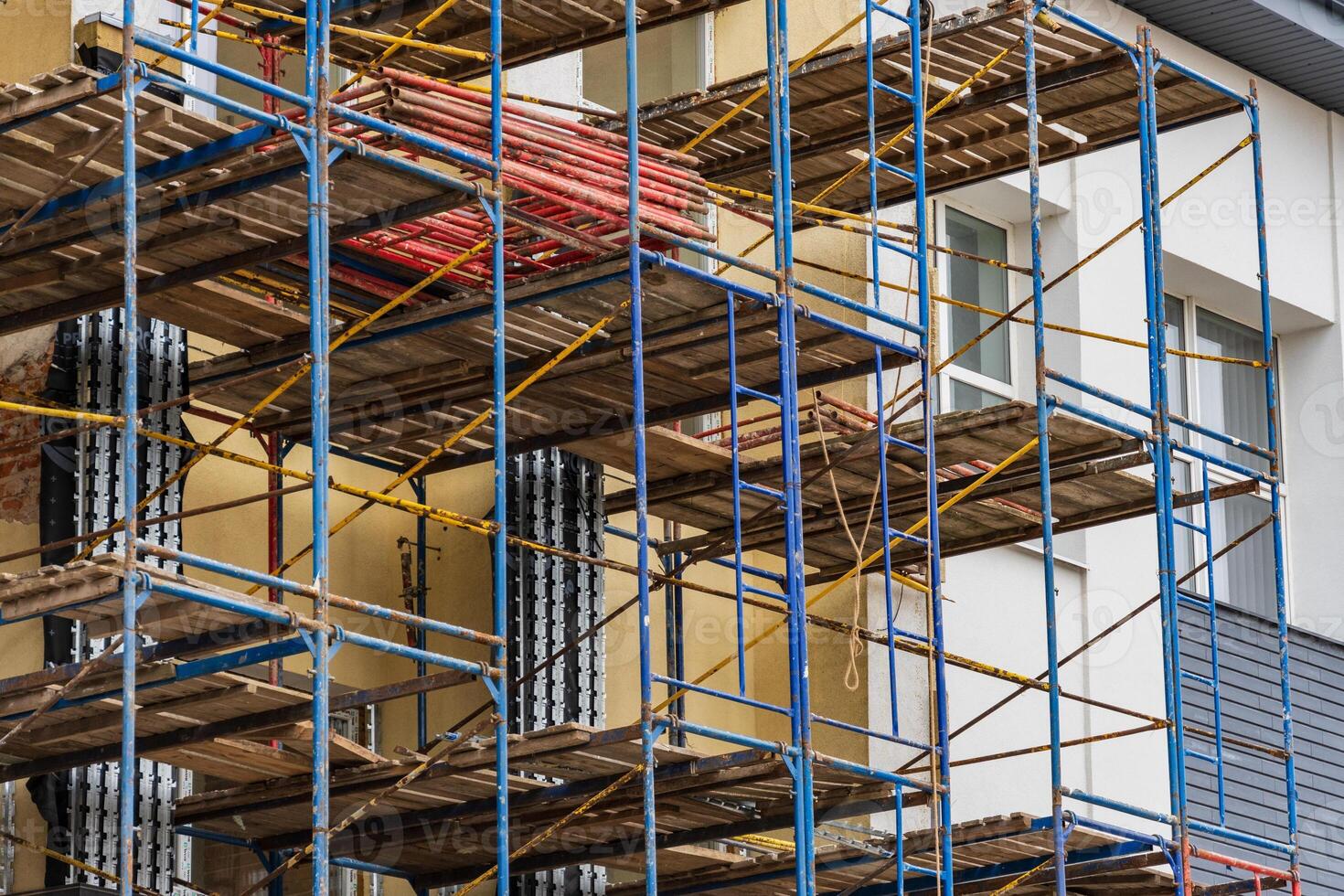 Workers prepare scaffolding around a building for renovation tasks while ensuring safety and accessibility for construction efforts photo
