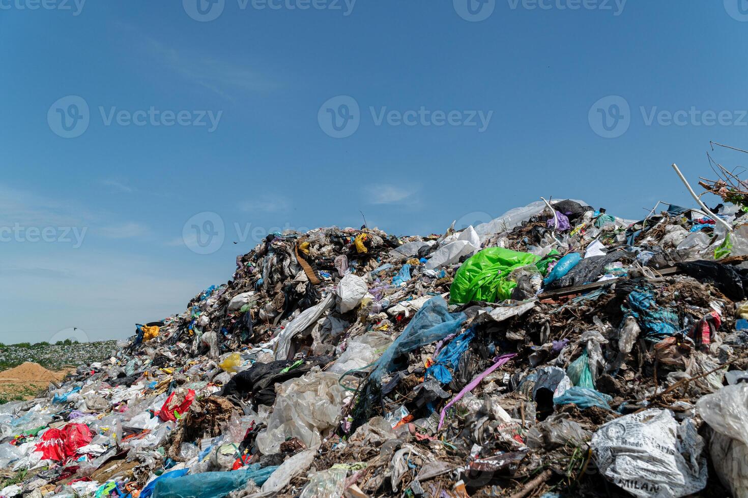 Plastic debris and waste materials mound high at a landfill site, showcasing the impact of pollution in the environment photo