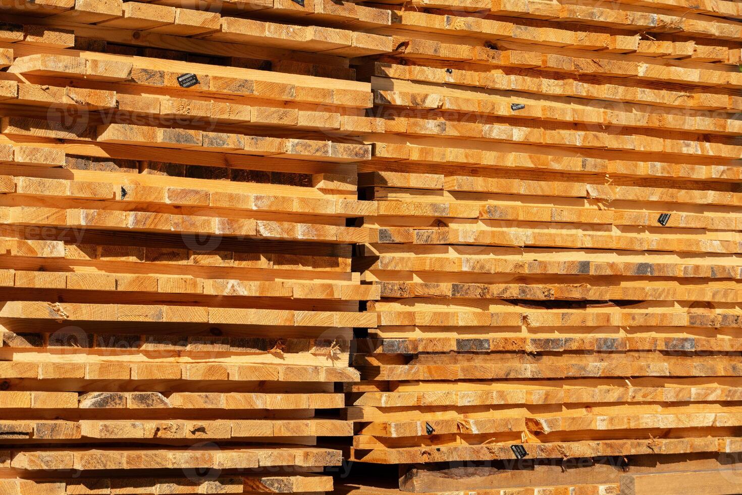 Timber logs are neatly stacked at a lumber yard, showcasing their rich color and smooth texture, highlighting the woodworking material's quality photo
