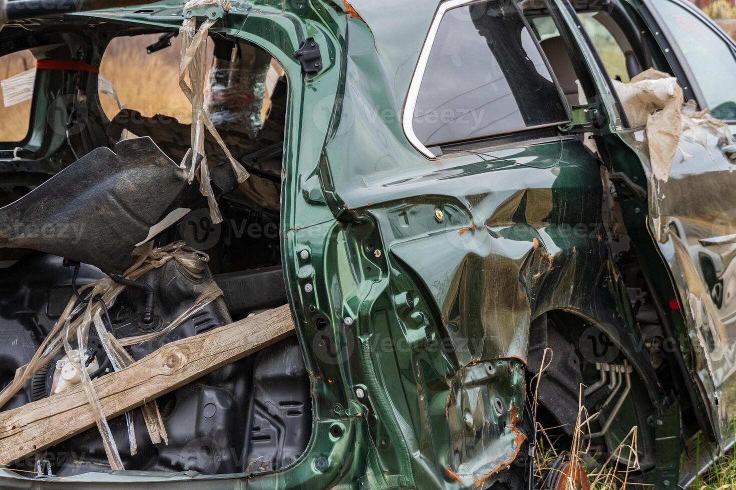 A damaged car is left abandoned on the side of a suburban road, highlighting the consequences of a severe crash and the need for safety photo